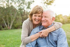 retired couple smiling at a park